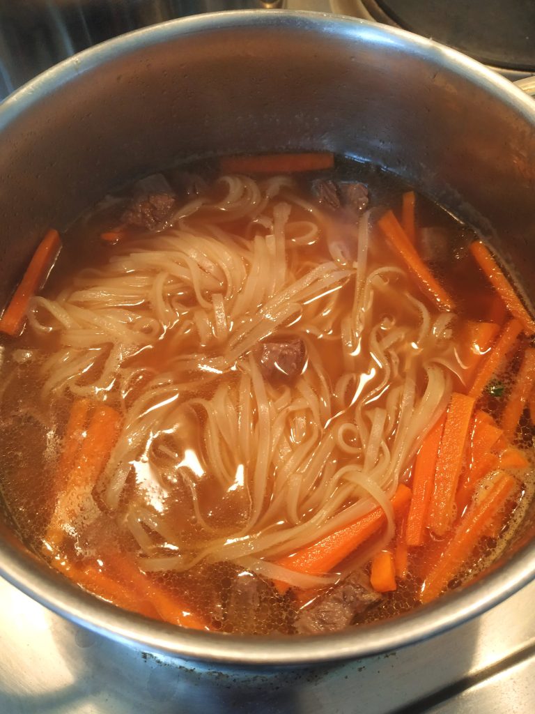Suppe mit Nudeln und Karotten kochen